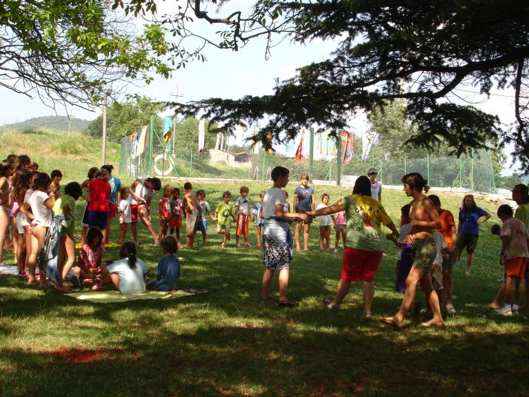 nens i nenes al camp al costat d'una piscina